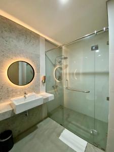 a bathroom with a sink and a glass shower at OPI Indah Hotel in Palembang