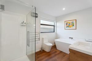 クロムウェルにあるMagnum Escape - Cromwell Holiday Homeの浴槽、洗面台、トイレを備えたバスルーム +10枚の写真