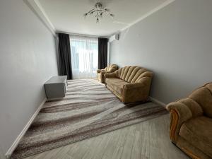 キシナウにあるRentWill apartments Simpleの椅子2脚とテーブルのあるリビングルーム