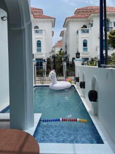 a pool with a unicorn float in the middle of a house at Spacious 6BR Villa Near Beach in Ha Long