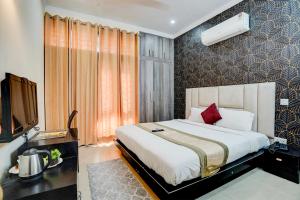 a hotel room with a bed and a television at Via Next Home - Nr IMT Chowk Manesar in Gurgaon