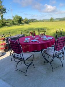 a table with a red table cloth and four chairs at Coeur et Nature in Colembert