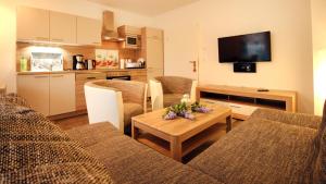 ein Wohnzimmer mit einem Sofa und einem Tisch sowie eine Küche in der Unterkunft Ferienwohnung Zinnowitz in Zinnowitz
