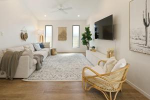 a living room with a couch and a tv at Home away from Home at Dicky Beach in Caloundra