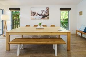 a wooden table with a bench in a room at Home away from Home at Dicky Beach in Caloundra +34 photos