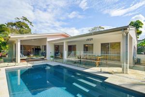a swimming pool in front of a house at Home away from Home at Dicky Beach in Caloundra