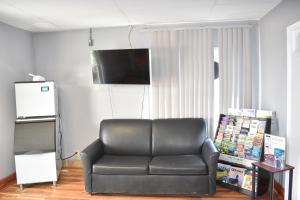 a living room with a leather couch and a television at Arlington inn in Arlington