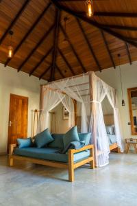 a blue couch in a room with a canopy at The Spice Trail in Arugam Bay