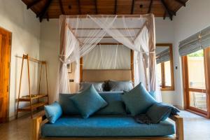 a blue couch in a room with a canopy at The Spice Trail in Arugam Bay
