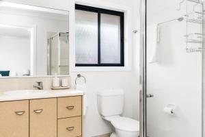 a bathroom with a toilet and a sink and a window at Serenity Now in Lennox Head +13 photos