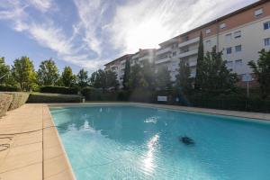 a large blue swimming pool in front of a building at Laissepassetemps in Marseille