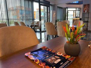 a book sitting on top of a wooden table with a vase at Skymoon Istanbul Airport Hotel in Arnavutköy
