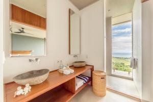 a bathroom with a sink and a window at Selong Selo Resort and Residences in Selong Belanak