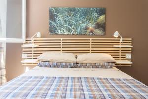 ein Schlafzimmer mit einem Bett mit zwei Kissen darauf in der Unterkunft Mondello Suites Feels Like Home in Mondello