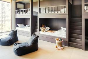 a childrens room with two bunk beds and a child laying in them at Selong Selo Resort and Residences in Selong Belanak