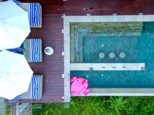 an overhead view of a swimming pool with a pink pig at Selong Selo Resort and Residences in Selong Belanak
