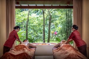 two women are washing a man in a bath tub at Adiwana Suweta in Ubud +42 photos