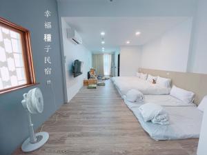 Xuejia幸福种子的客厅里有两张白色沙发和一台风扇
