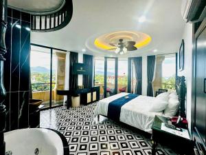 a bedroom with a bed and a bathroom with a tub at Nereus Hotel in Con Dao