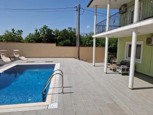 a swimming pool on a patio next to a house at Villa Aberdeen in Tivat