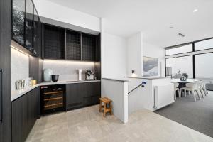 a kitchen with black and white cabinets and a table at Luxury KH Chalet in Mount Hotham +7 photos