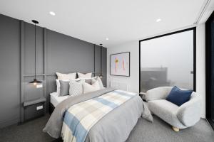 a bedroom with a bed and a chair at Luxury KH Chalet in Mount Hotham