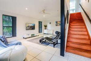 a living room with a staircase and a chair at Swell Life - Spacious 3-Bedroom Retreat in Central Agnes Water in Agnes Water