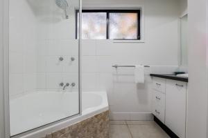 a white bathroom with a tub and a shower at Swell Life - Spacious 3-Bedroom Retreat in Central Agnes Water in Agnes Water +20 photos