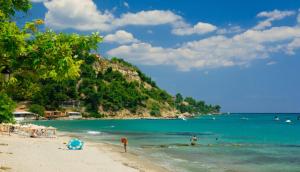 Sofia's house في بوسيدي: شاطئ فيه ناس في الماء وجبل