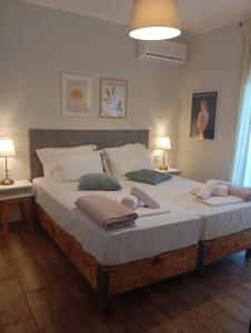 イオアニナにあるKaterina's guest houseの大型ベッド(白いシーツ、枕付)