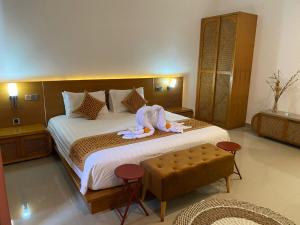 a hotel room with a large bed with a robe on it at Villa Julia in Sanur +18 photos