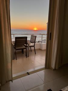 a balcony with a table and chairs and the ocean at Bluemoon Suites Sarande in Sarandë +75 photos