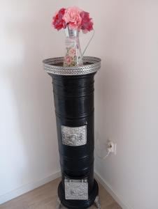eine schwarze Säule mit einer Vase mit Blumen darin in der Unterkunft House Daniela in Omišalj