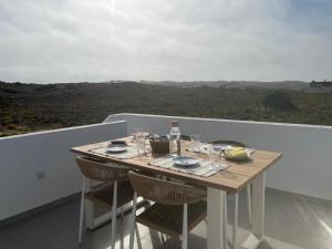 a table on a balcony with a view at Casa Zavial in Carrapateira +4 photos