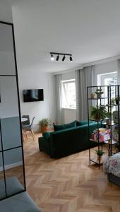 a living room with a green couch and a table at Apartament nad Jeziorem Drwęckim w Ostródzie z klimatyzacją in Ostróda +13 photos