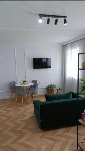 a living room with a green couch and a table at Apartament nad Jeziorem Drwęckim w Ostródzie z klimatyzacją in Ostróda