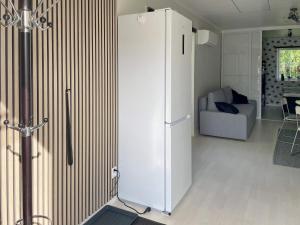 a white refrigerator in a living room with a couch at 4 star holiday home in SÖLVESBORG in Sölvesborg +12 photos