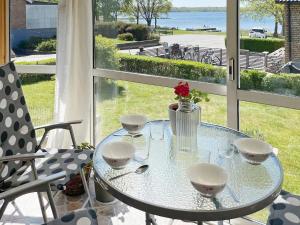 a glass table with glasses and a vase with flowers at 4 star holiday home in Sturkø in Karlskrona