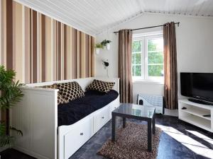 a living room with a couch and a tv at 10 person holiday home in Skummeslövsstrand in Skummeslövsstrand