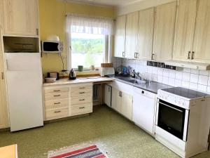 a kitchen with white cabinets and a white refrigerator at 4 person holiday home in BURTRÄSK in Burträsk