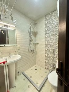 a bathroom with a shower and a toilet and a sink at Aqua Batumi 44 in Batumi