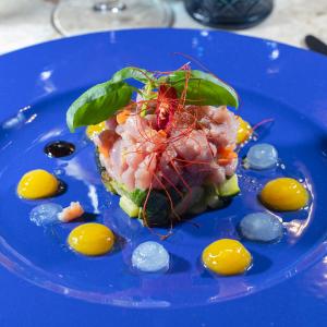 a blue plate with a seafood dish on it at Selinunte Boutique Hotel in Marinella di Selinunte