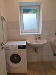 a bathroom with a washing machine and a sink at Beautiful Spacious Apartments near Hamburg in Ahrensburg