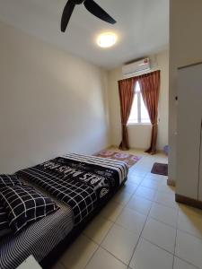 a bedroom with a bed and a ceiling fan at Homestay Adleya in Bagan Serai +14 photos