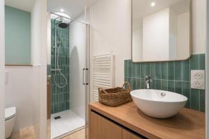 a bathroom with a white sink and a shower at La maison du Sophora grande maison 3 chambres in Saint-Didier-de-Formans