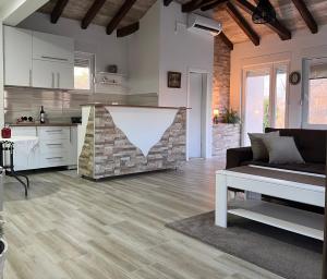 ein Wohnzimmer mit Couch und Küche in der Unterkunft Odmor uz Trebišnjicu in Trebinje