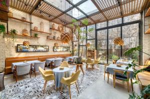 a restaurant with tables and chairs and a glass ceiling at 杭州忆栖生态艺术酒店西溪湿地店 in Hangzhou