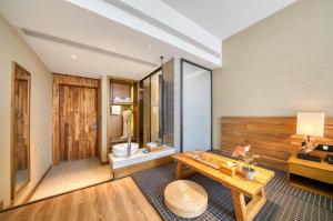 a living room with a table and a bathroom at 杭州忆栖生态艺术酒店西溪湿地店 in Hangzhou +40 photos