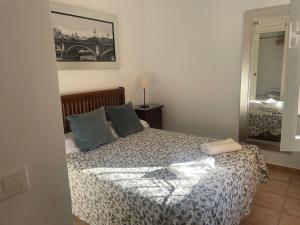 ein Schlafzimmer mit einem Bett mit blauen Kissen und einem Spiegel in der Unterkunft Palo verde-Golf-Playa-Islantilla in Islantilla + 23 Fotos