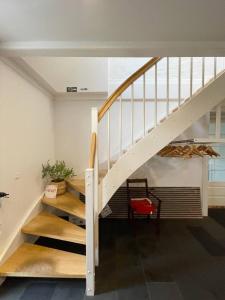 a staircase in a house with a red chair at Fjelstrup Kro in Haderslev